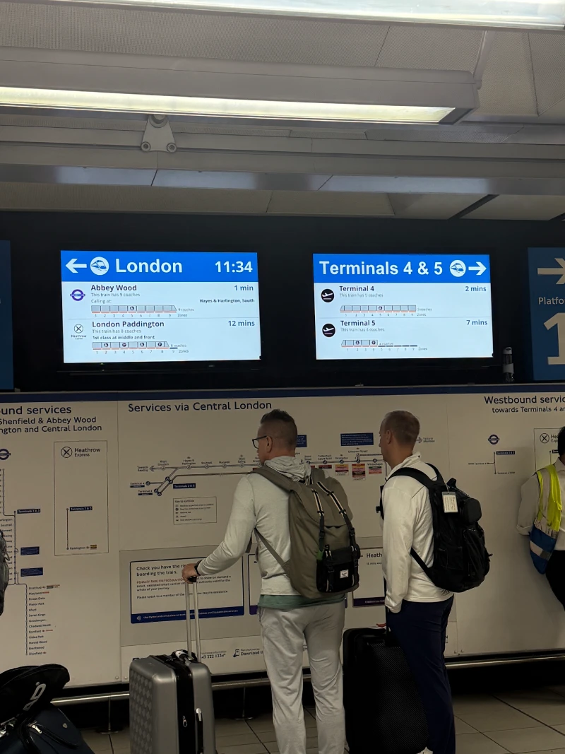 Two travellers reading the departure board at Heathrow
