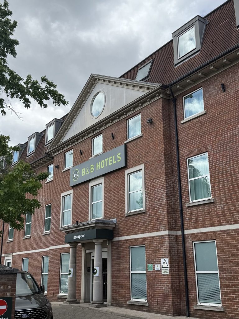 The B&B Hotel Heathrow building, a red-brick block with a pediment, in Colnbrook