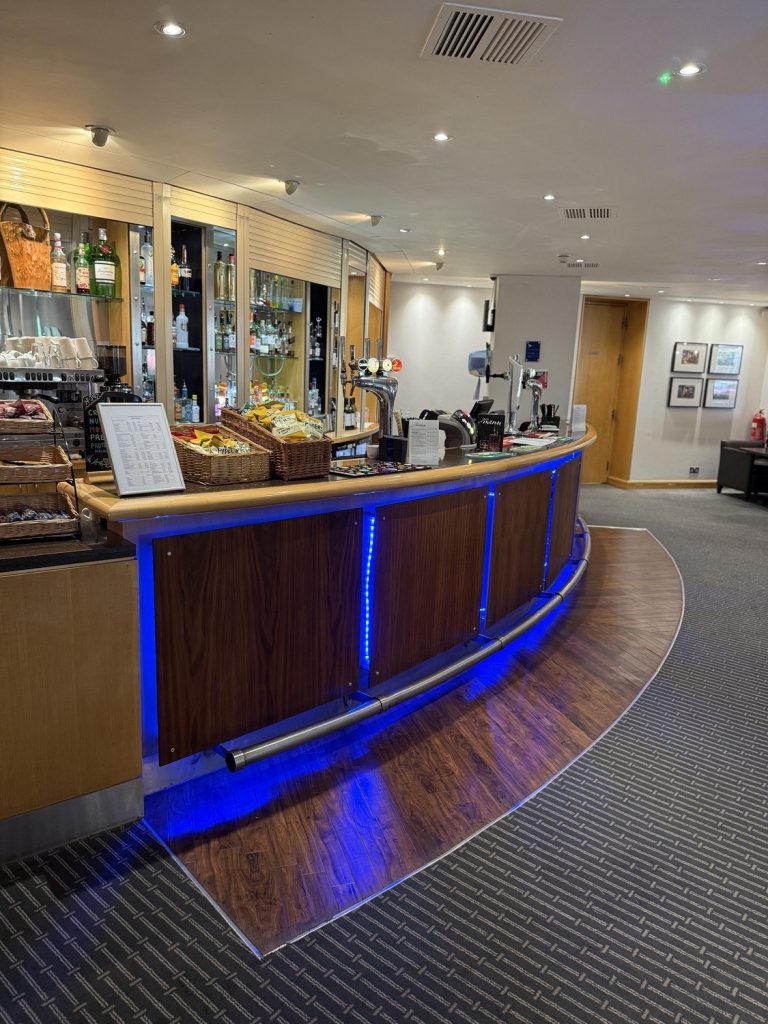 The bar at the Best Western Heathrow, a curved counter lit with blue light