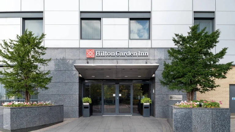 Entrance to the Hilton Garden Inn at Hatton Cross, with the sign above the doors between two trees