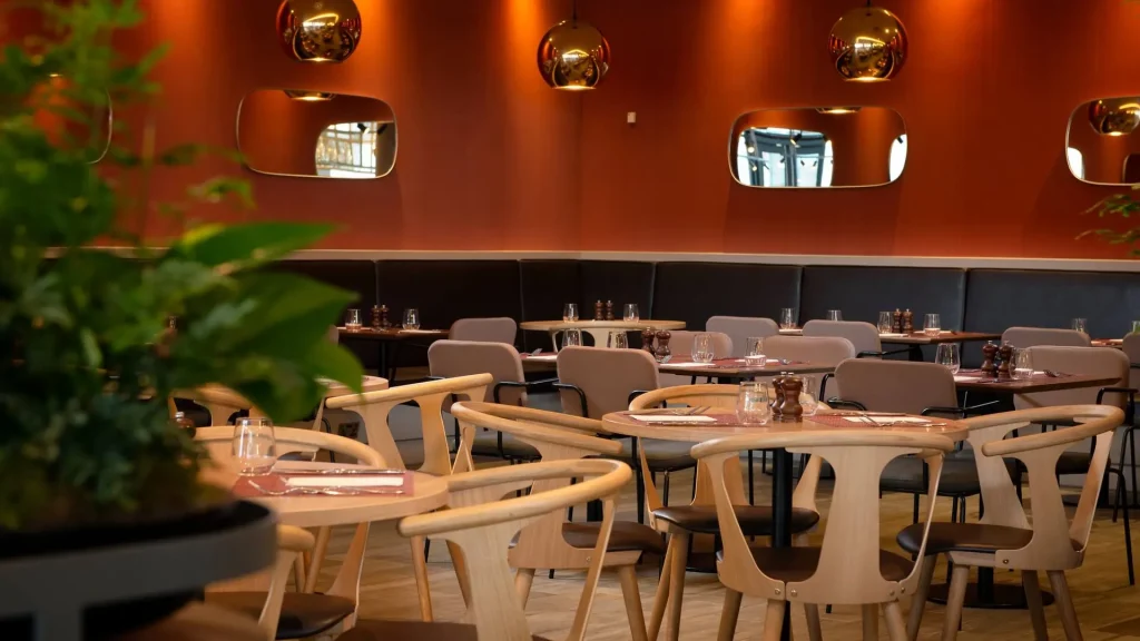 Restaurant at the Hilton Garden Inn at Hatton Cross, with copper pendant lights against a deep orange wall