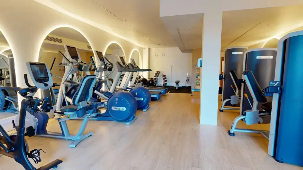 Gym at the Hilton London Heathrow Terminal 5, with treadmills and exercise bikes under arched lighting