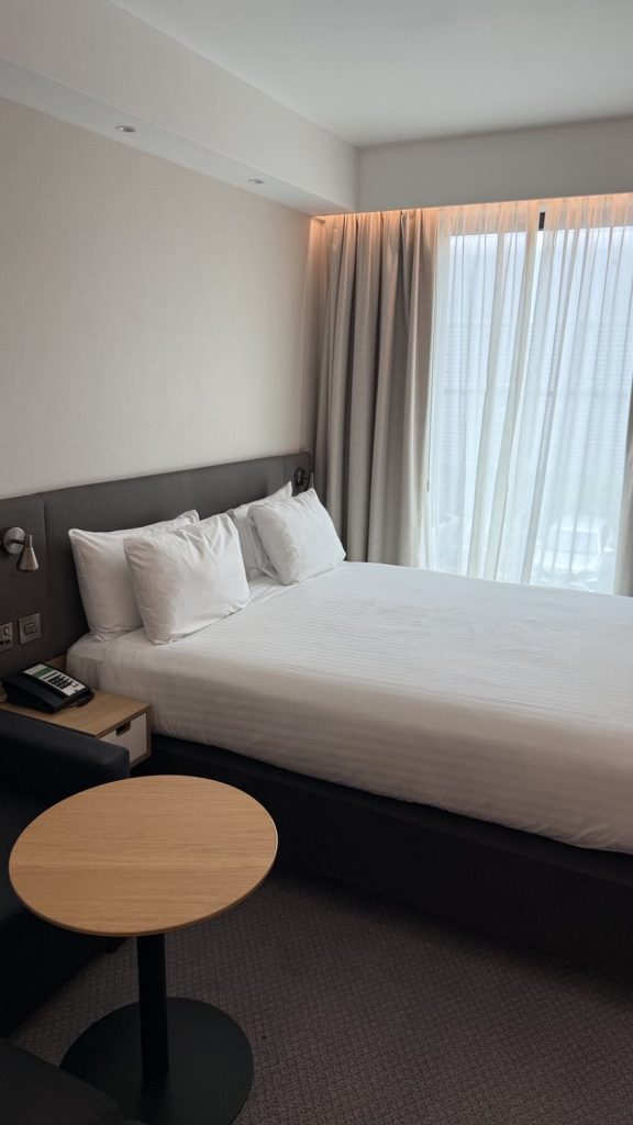 A standard room with a double bed and a window seat