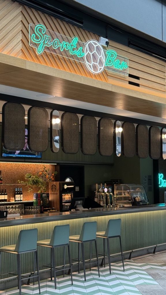 The sports bar, with a neon sign above the counter