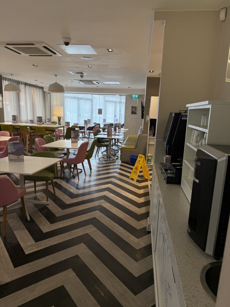 The restaurant at ibis Styles Heathrow with a chevron floor and dining tables