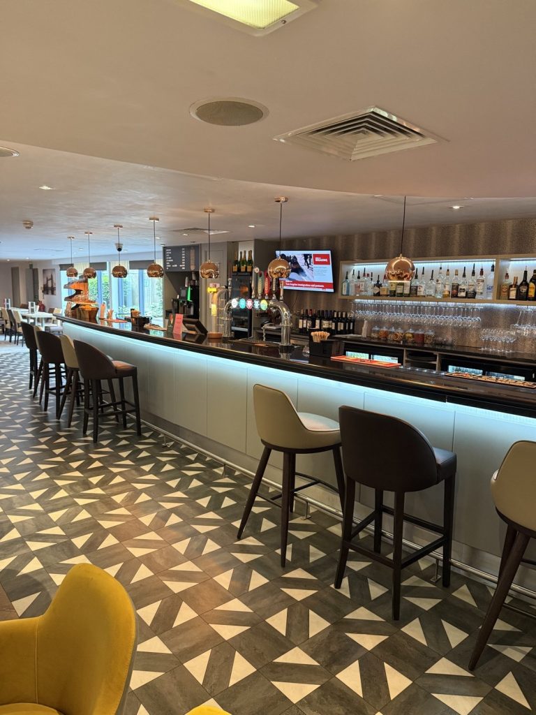 The bar, with stools along the counter and a patterned floor