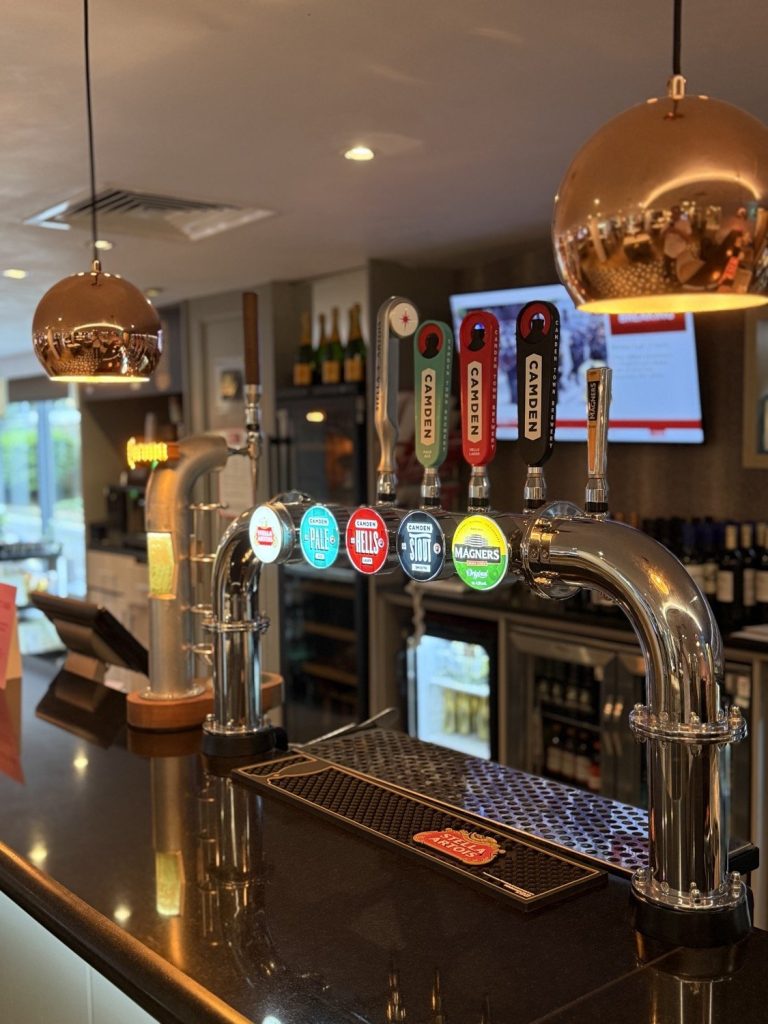 Beer taps on the bar, under copper pendant lights