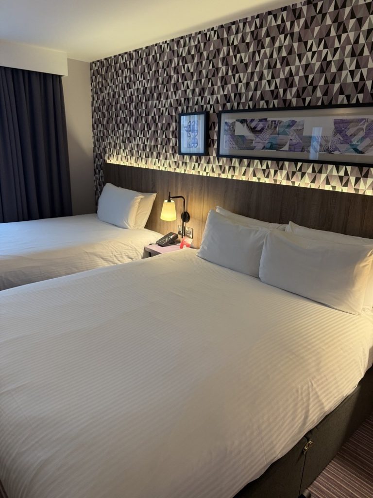 A guest room with a patterned headboard wall