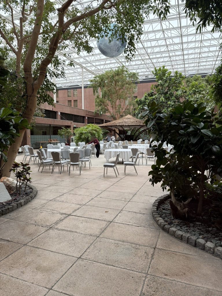 The tropical Sky Garden at the Sheraton Skyline Heathrow, a glass-roofed atrium with trees and tables set for dining