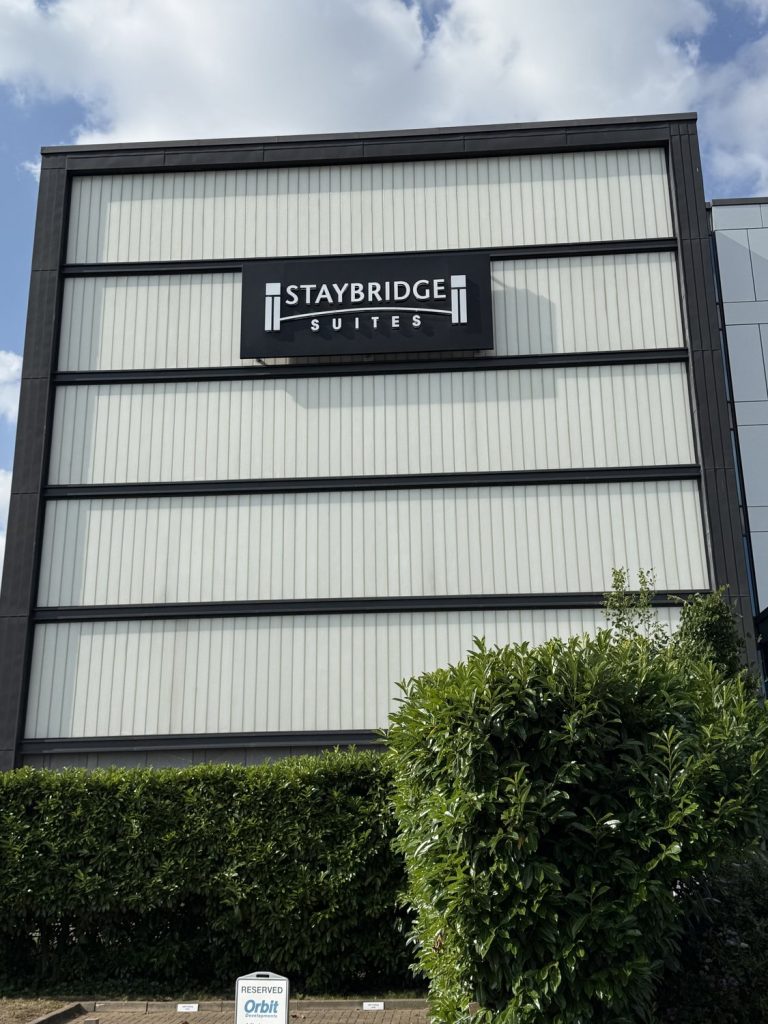 The Staybridge Suites sign on the building, seen from the road