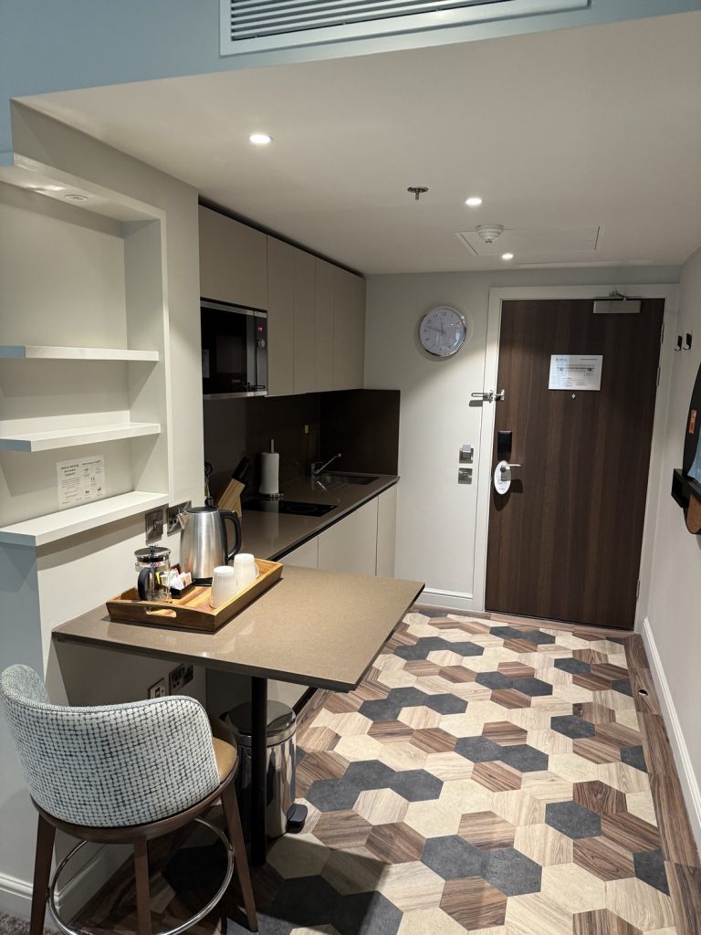 A studio suite, with a kitchenette and a dining table by the door
