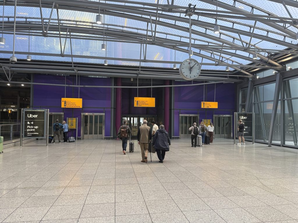 Leaving Terminal 5 arrivals, with the bus stops signed ahead and the Uber pick-up point to the left