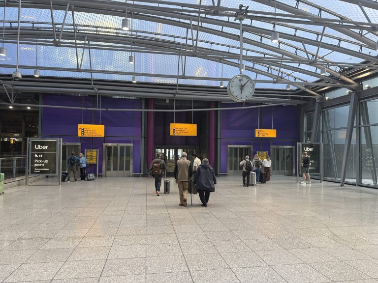 Leaving Terminal 5 arrivals, with the bus stops signed ahead and the Uber pick-up point to the left